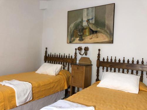 a room with two beds and a painting on the wall at Las Casitas de Layos in Layos