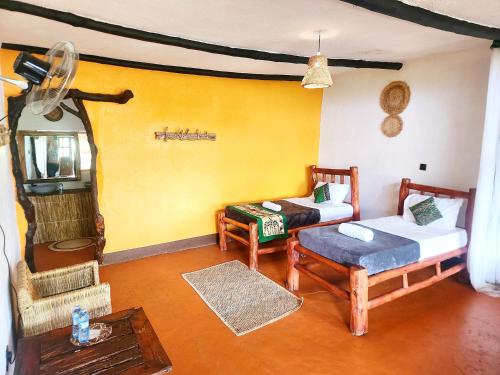 a room with a bed and a couch and a table at Hornbill Bush Lodge in Pakwach East