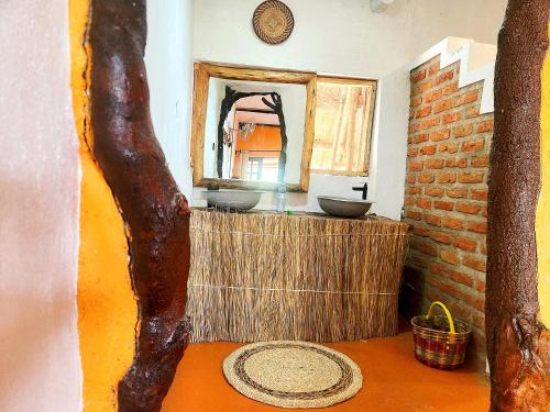 a bathroom with a mirror and a sink in a room at Hornbill Bush Lodge in Pakwach East