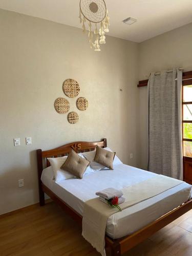 a bedroom with a large bed with white sheets at Rekanto Sabiá in Jijoca de Jericoacoara