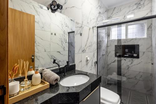 a bathroom with a sink and a shower at Casa completa 2 Quartos, garagem privativa e Self check-in -Ideal para famílias, casais e profissionais em trabalho remoto in Campo Grande