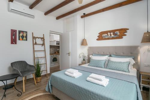 a bedroom with a blue bed and a chair at Glaucus Summer House sea view in Mandrakia
