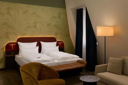 a hotel room with a bed and a chair at The Cloud One Frankfurt-Metropolitan in Frankfurt