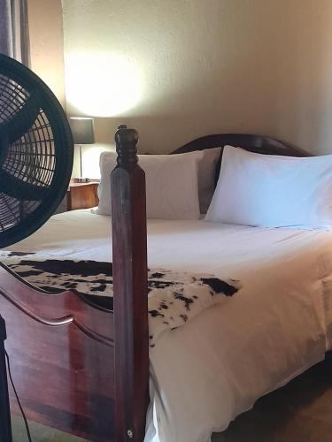 a bedroom with a bed with a wooden bed frame at African Bushveld 129A 1 x Bachelor Unit in Buffelspoort