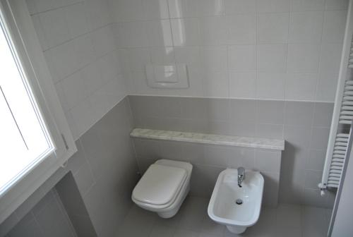 bagno bianco con servizi igienici e lavandino di A Zonzo a Vicenza