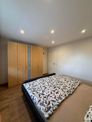 a bedroom with a bed with a black and white blanket at Ferienwohnung Carina in Losheim
