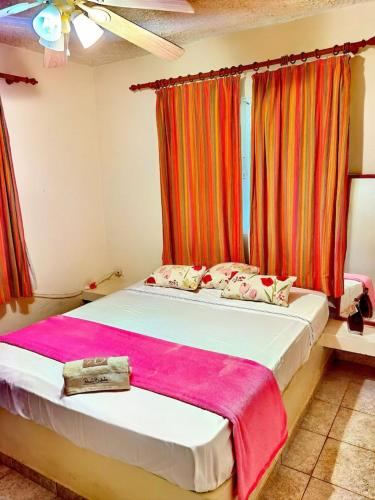 a bedroom with a bed with a pink blanket on it at Casa mar in Las Galeras
