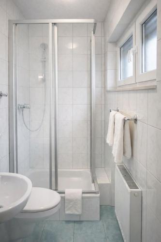 ein weißes Badezimmer mit Dusche und Waschbecken in der Unterkunft Hotel Discovery in Stuttgart