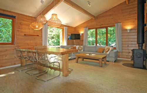 a living room with a table and chairs and a couch at De Roek Vakantiebungalows in Otterlo