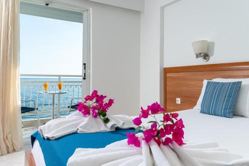 a bedroom with a bed with pink flowers on it at Meridien Beach Hotel in Argassi