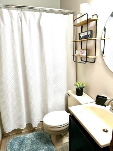 a bathroom with a white shower curtain and a toilet at Alumni Corner in State College
