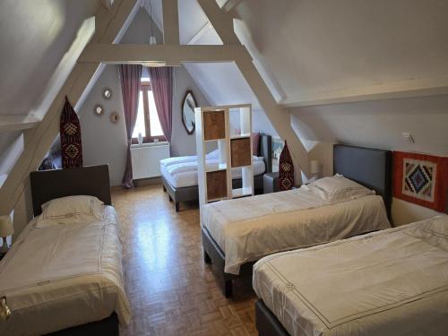 a attic bedroom with two beds and a room with two beds at Group accommodation in Borgloon Hof Van Kalenberg in Borgloon