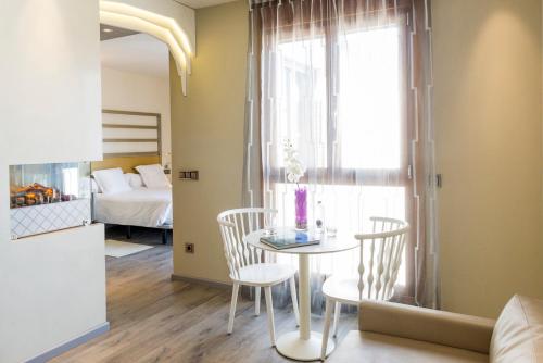 a room with a table and chairs and a bed at Hotel & Spa Princesa Munia in Oviedo