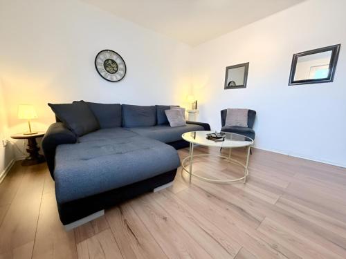a living room with a blue couch and a table at FeWo Lindenallee Modern & Ruhig in Nordhorn