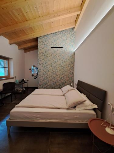 a bedroom with a large bed and a table at B&B Le Origini in Ledro