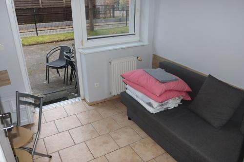 a living room with a couch with pillows on it at Minuta do plaży - Sarbinowo in Sarbinowo