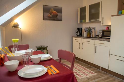 a kitchen and dining room with a red table and chairs at Eulennest-OWL in Bad Salzuflen