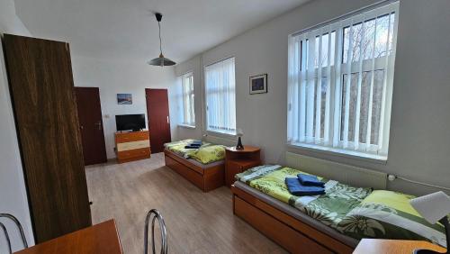 a room with two beds and a desk and a table at U vodohospodárov in Banská Štiavnica