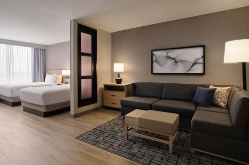 a hotel room with a couch and a bed at Hyatt Place Tampa Airport/Westshore in Tampa
