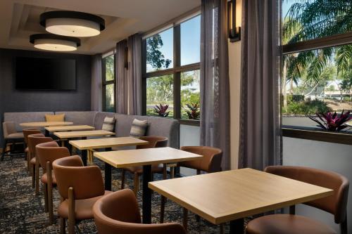 a row of tables and chairs in a room with windows at Hyatt Place Tampa Airport/Westshore in Tampa