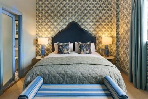 a bedroom with a large bed and two lamps at Hotel du Vin Henley in Henley on Thames