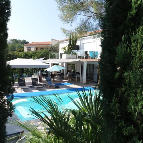 a villa with a swimming pool and a house at Villa Perle De La Mer in Saint-Aygulf