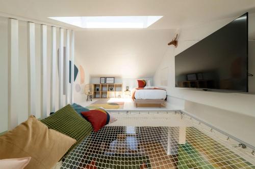 a living room with a couch and a tv at Air Nomad • Vancouver in Valenciennes