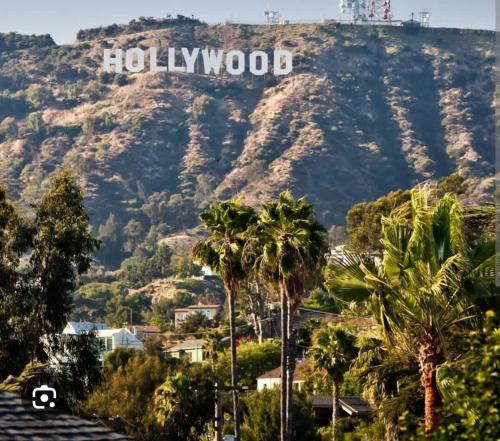 a view of a mountain with a hollywood sign on it at 2Bed Apt View of Hollywood Sign & Rooftop Pool in Los Angeles