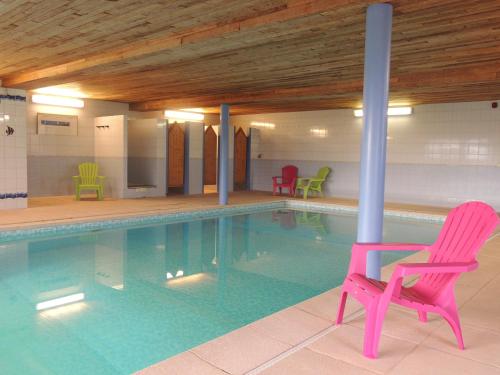 a pool with a pink chair and chairs in it at Gite 2 de Renuamont in Sainte-Ode