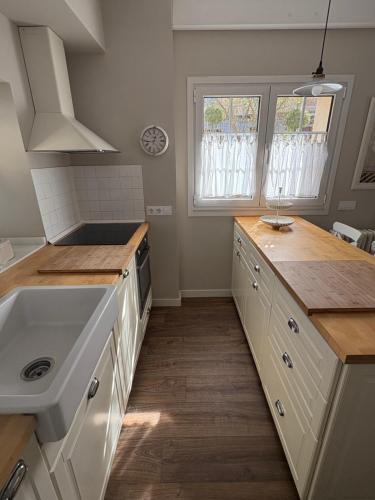 a kitchen with white cabinets and a sink at La Casa de Nueva in Nueva de Llanes