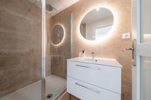 a bathroom with a sink and a shower at Air Nomad • Séville in Valenciennes