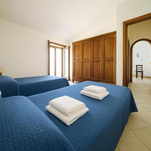 a blue bed with two white towels on top of it at Casa Vacanze Orosei in Orosei