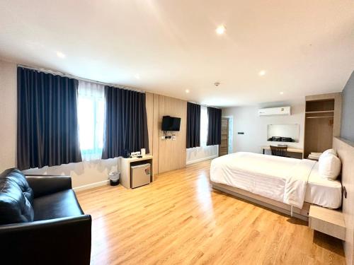 a large bedroom with a bed and a couch at V1 boutique hotel in Kanchanaburi City