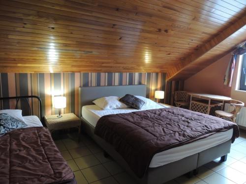 a bedroom with a large bed and a wooden ceiling at Gite 2 de Renuamont in Sainte-Ode