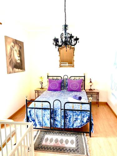 a bedroom with a bed and a chandelier at Zenit marina village Olhao T2 appartement in Olhão