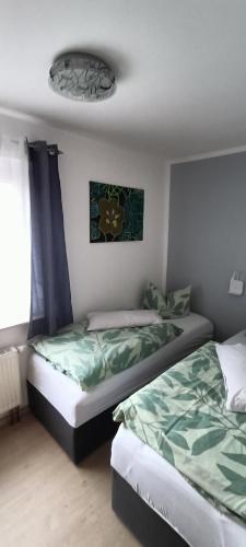 two beds sitting next to each other in a bedroom at Ferienwohnung Tschitschmann in Naumburg