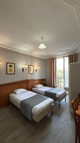 a hotel room with two beds and a window at Hotel Richmond Gare du Nord in Paris
