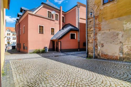 a cobblestone street in a town with pink buildings at Nefrit Garni & Bar in Česká Kamenice