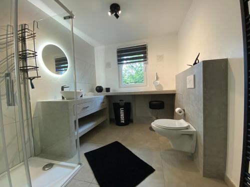 a bathroom with a toilet and a sink and a shower at Bandrew in Stoumont