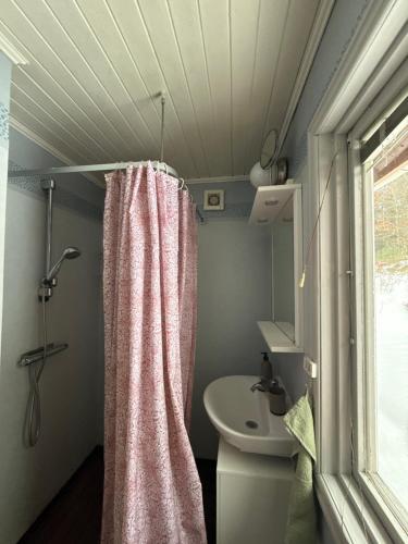 a bathroom with a shower curtain and a toilet at Mormors hus in Jörlanda