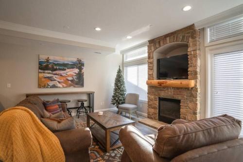 a living room with a couch and a fireplace at Lakeside Funscape LS33 Ski & Snowboard Hot Tub in Huntsville