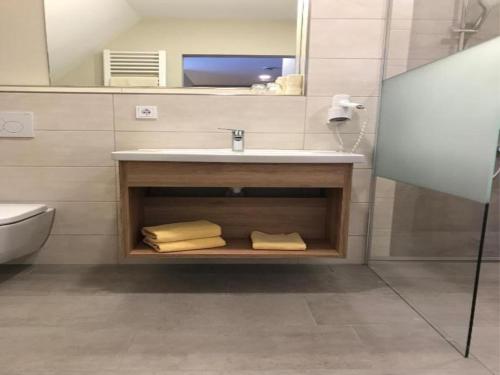 a bathroom with a sink and a mirror and towels at Hotel-Gasthof Neue Post in Leutershausen