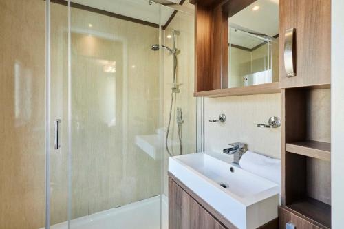 a bathroom with a sink and a glass shower at Lakeside Gem with Hot Tub in York