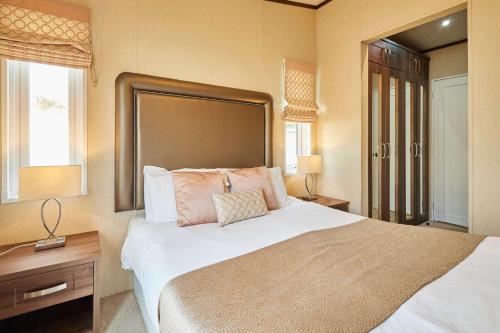 a bedroom with a large white bed and a window at Lakeside Gem with Hot Tub in York