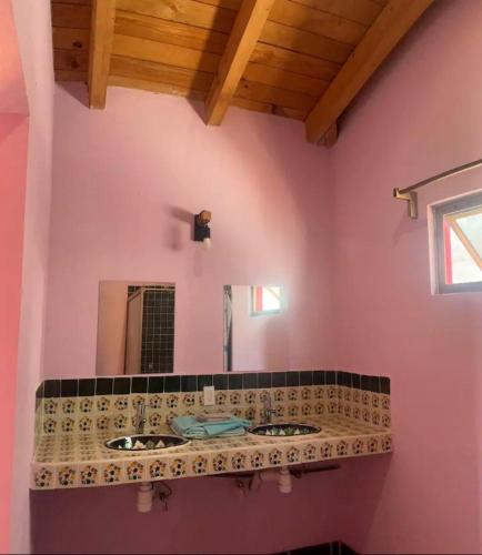 a bathroom with two sinks and a mirror at Las Casitas de La Bahia Calechosa in Emiliano Zapata
