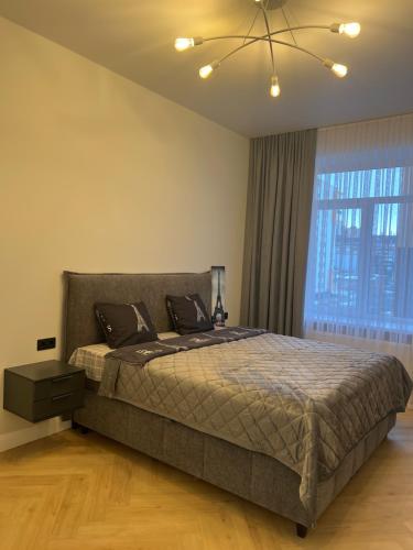 a bedroom with a bed and a large window at Квартира подобово класу "ЛЮКС" in Khmelnytskyi