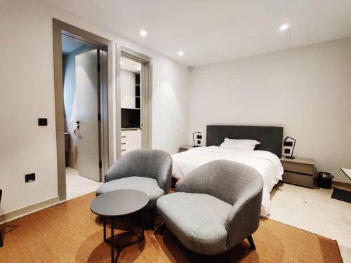 a bedroom with two chairs and a bed at Villa Lippia in Misraħ Miel