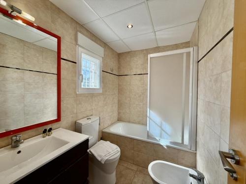a bathroom with a tub and a sink and a toilet at Los Olivos - Casa Adosada in Peniscola