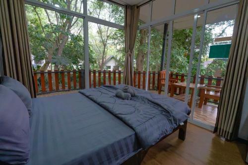a bedroom with a bed with a teddy bear on it at อินทนนท์ขุนเล่าลือ in Ban Na Yang
