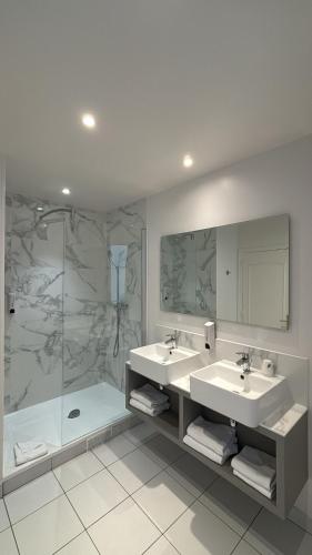 a bathroom with two sinks and a shower at Hotel Richmond Gare du Nord in Paris